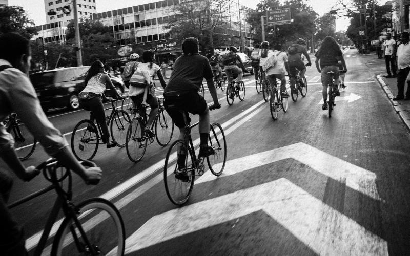 The essence of exceptional living a group of bicyclists riding down a street