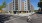a person riding a bicycle on a street in front of a large building